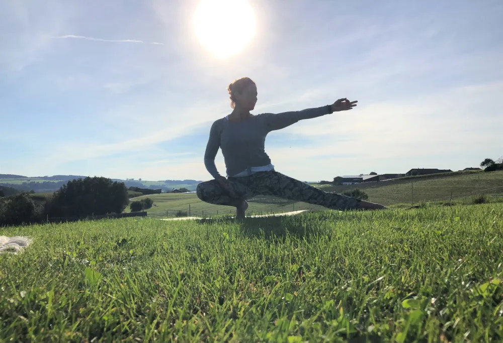 Yoga bei Sonnenaufgang auf einer Wiese bei Manching